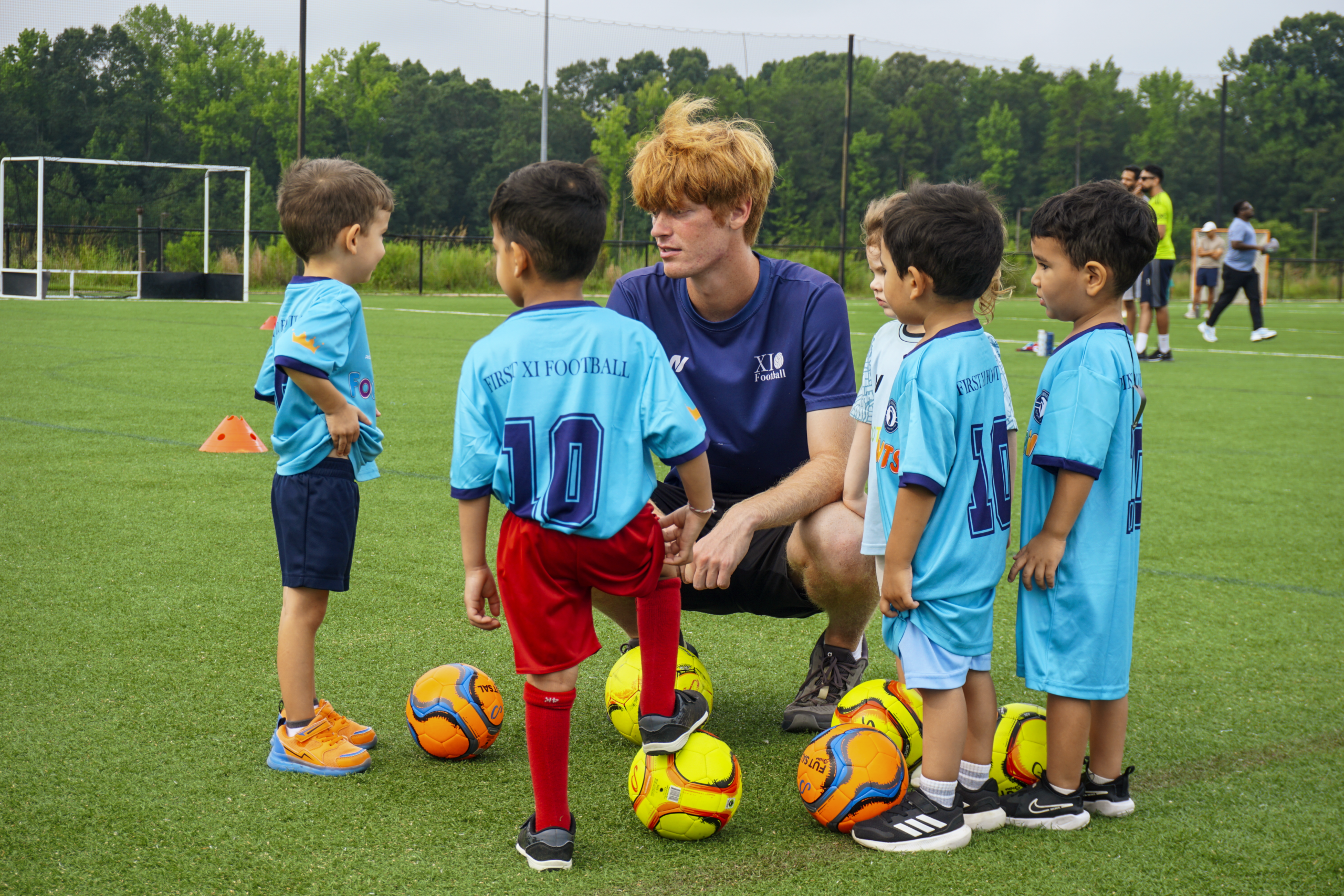 A Footprints coach working with a group of young soccer players