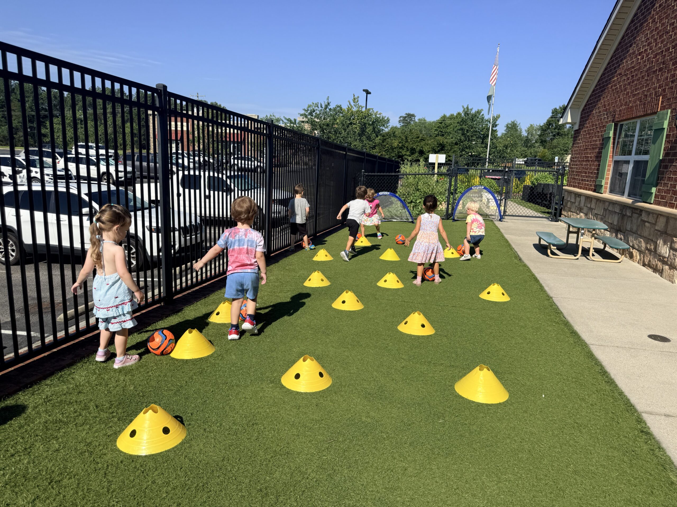 Preschool children practicing soccer in their school play area